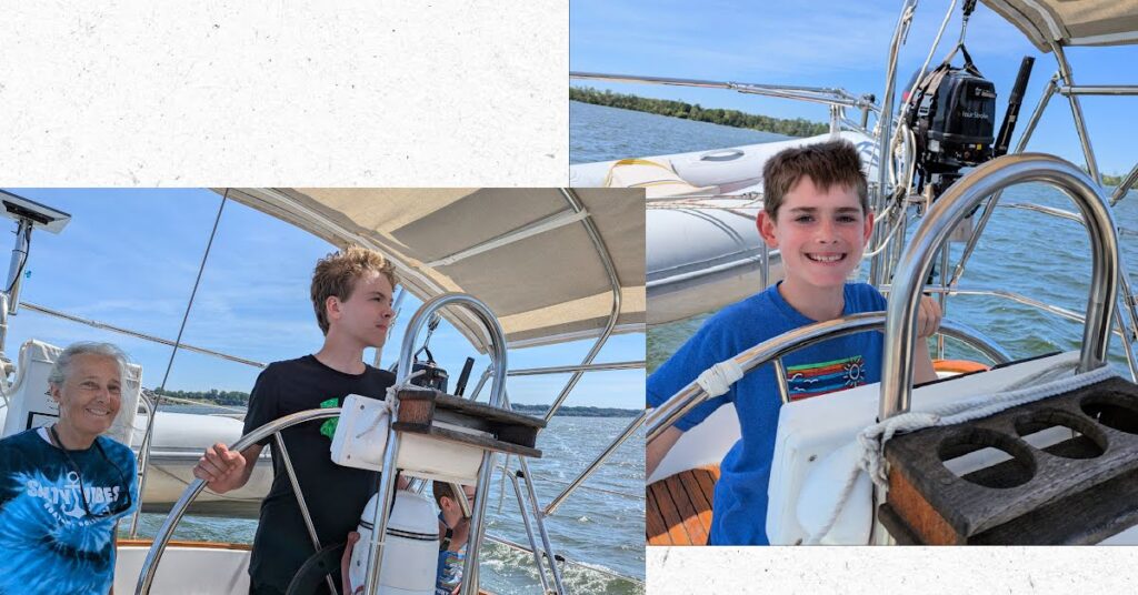grandsons at the helm of sailboat with grandma seated nearby 

