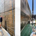 man and woman on deck of sailboat working lines in a lock